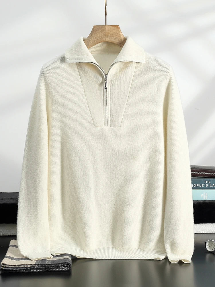 Pull en laine blanc cassé avec col zippé, suspendu sur un cintre en bois. Design élégant et moderne, idéal pour l'hiver. Mode homme tendance.