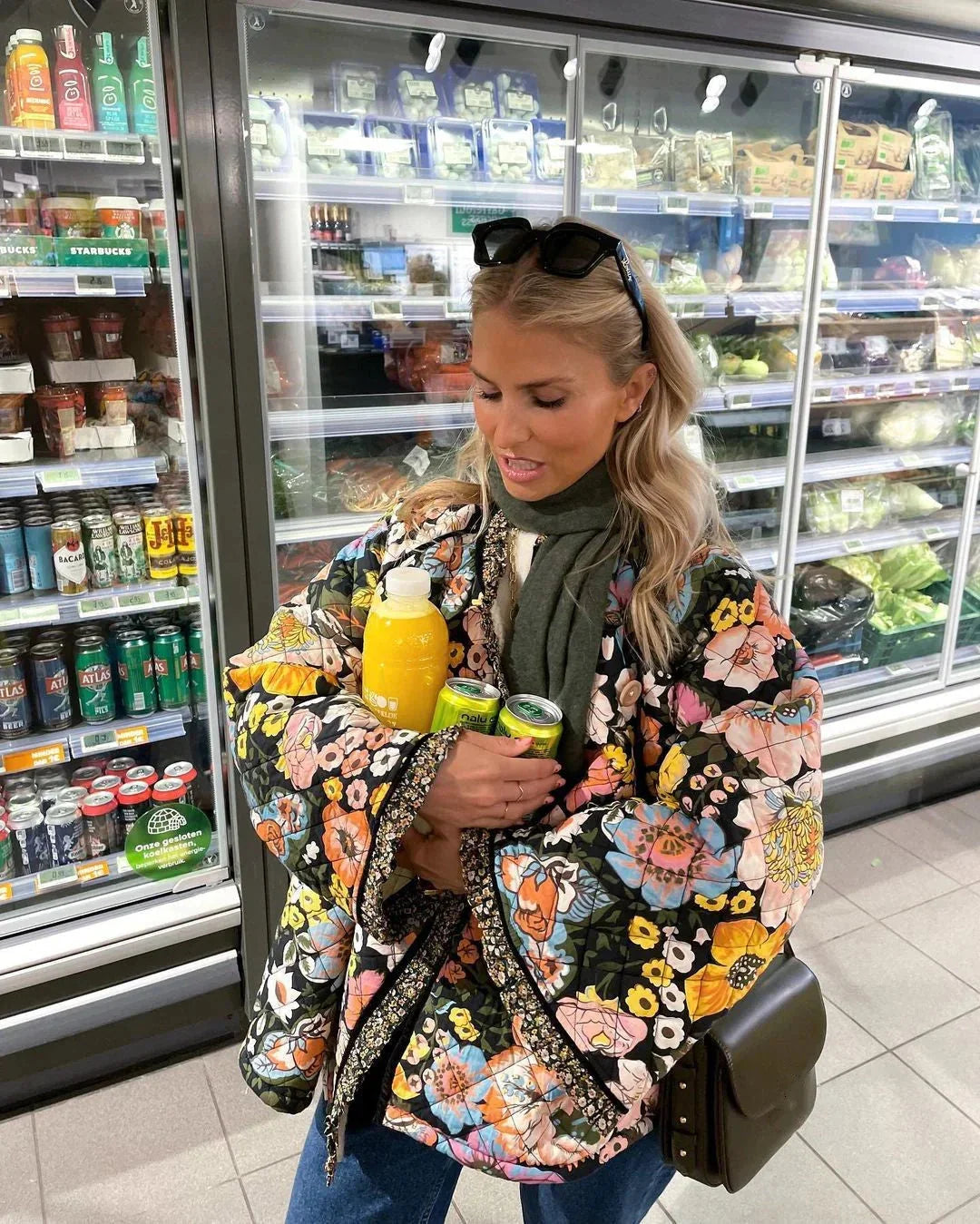 
A vibrant multicolor floral puffer jacket for women displayed on a retail display, showcasing its trendy design suitable for winterwear.
