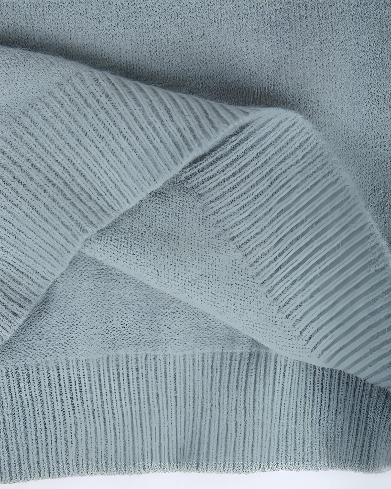 Mint green Fair Isle women's sweater with a cozy Scandinavian knit pattern, featuring intricate geometric designs in shades of grey and electric blue. The sweater is displayed against a wooden backdrop, highlighting the textile's texture and pattern.