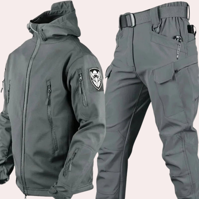 Waterproof hooded tactical jacket and cargo pants set in gray, size 4XL, featuring a durable design suitable for outdoor activities with intricate details such as a secure collar, adjustable waist, and ample pocket space for functionality.