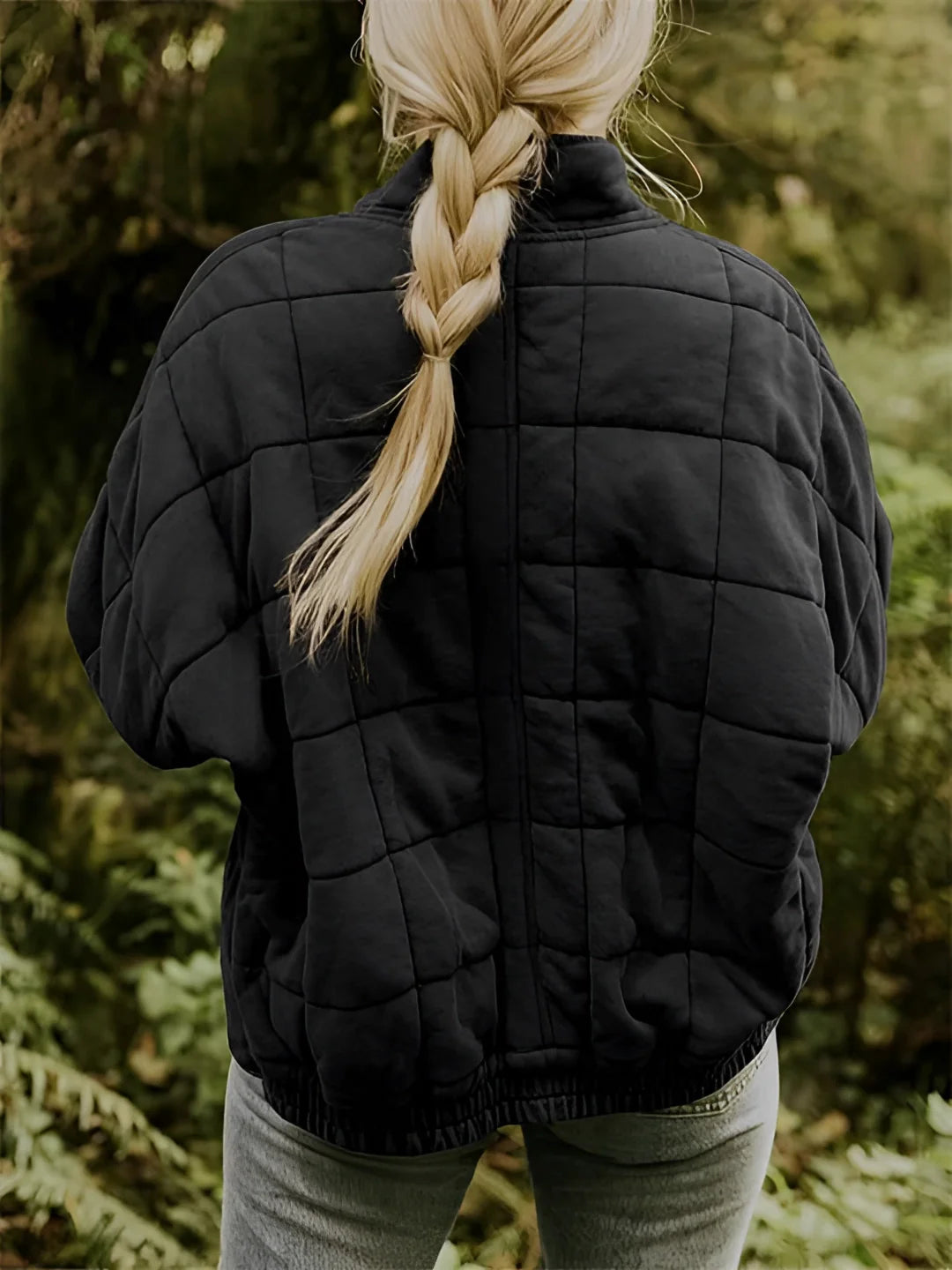Women's forest green quilted jacket with a lightweight design, featuring long sleeves, worn by a person with long hair standing in a natural setting.