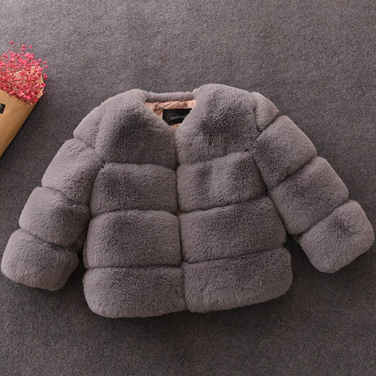 Grå faux pelsjakke på gråt tæppe, elegant og moderne design, perfekt til vintermode. Blød tekstur, stilfuld og varm beklædning til kvinder.