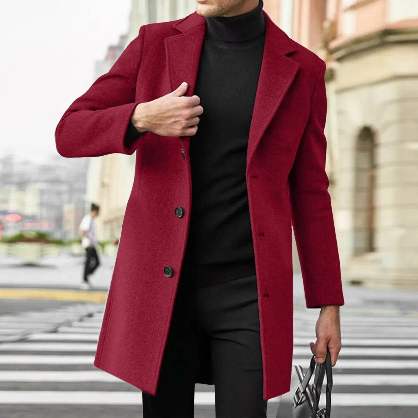Mand iført rød frakke og sort turtleneck, krydser gade i bymiljø. Elegant herremode, vinterfrakke, stilfuldt tøj, moderne byliv.