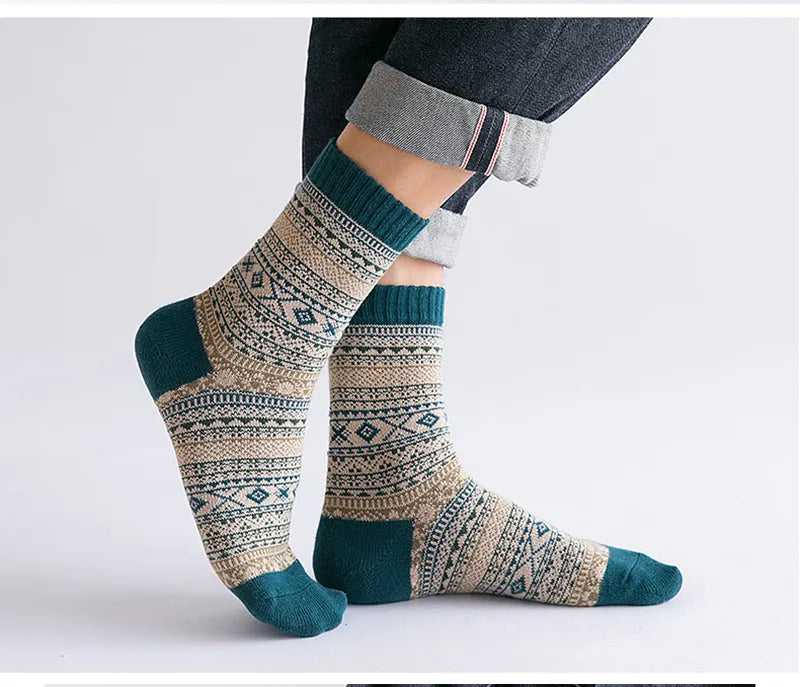 Person iført mønstrede uldsokker i beige og blå med geometrisk design. Komfortable, varme sokker til vinterbrug. Mode, tilbehør, hygge.