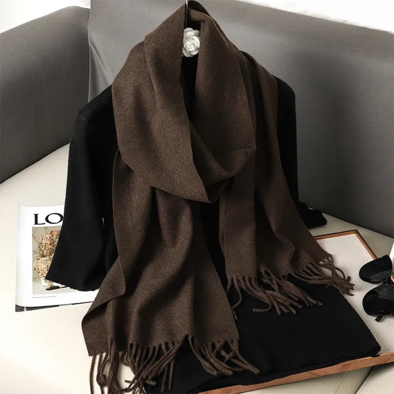 Brun uldhalstørklæde med frynser på sort sweater, placeret på sofa. Modeaccessories, vintertøj, stilfuldt design, komfortabelt og varmt.