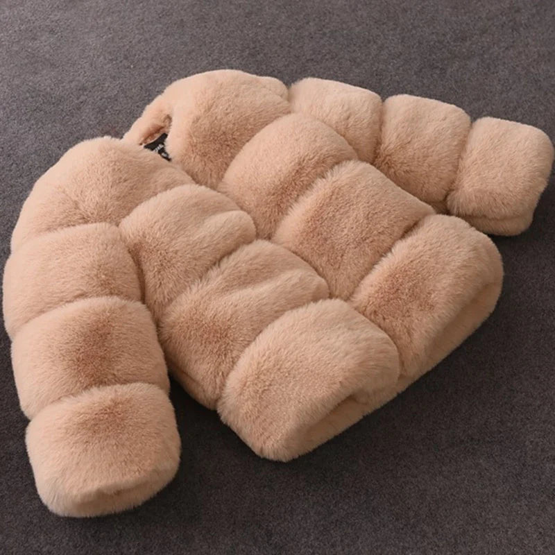 Beige faux pelsjakke på grå baggrund, blød og luksuriøs. Perfekt til vintermode og stilbevidste kvinder. Trendy overtøj til kolde dage.