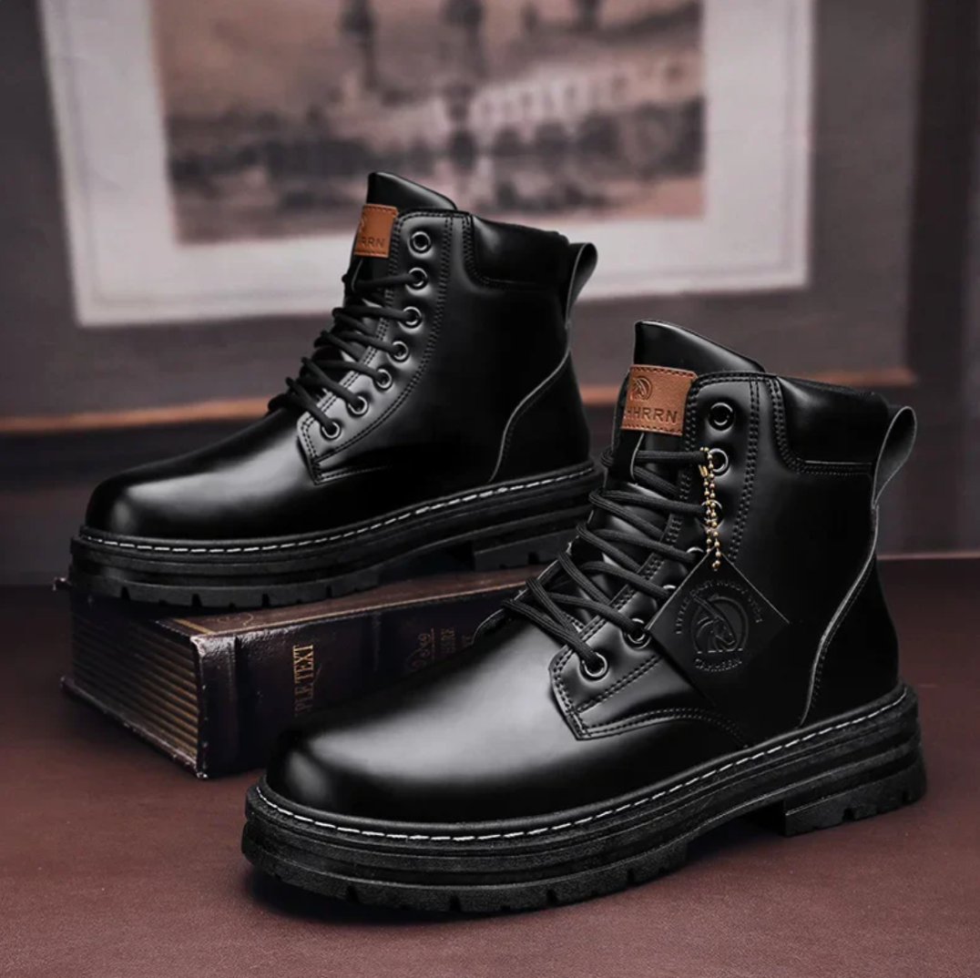 Bottes en cuir noir pour homme, style militaire, lacets robustes, semelle épaisse antidérapante, posées sur des livres, mode automne-hiver.