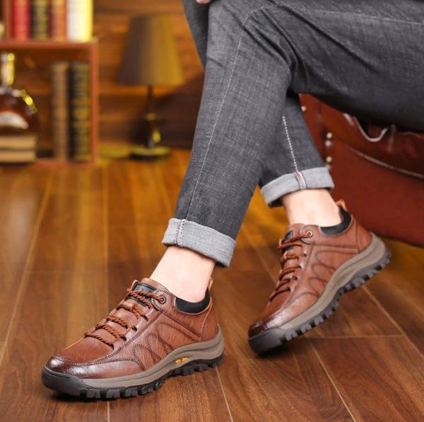 Chaussures en cuir marron pour homme sur parquet, style décontracté, jeans retroussés, ambiance chaleureuse. Mode masculine, confort, élégance.